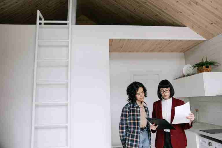 Real Estate Agent vs Property Manager comparison showing two Australian real estate professionals reviewing a property market report and discussing career pathways, responsibilities, and industry insights.