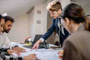 Senior real estate professional closing a property deal with clients, demonstrating How to Land Senior Roles in Property through strong leadership, negotiation and relationship management.